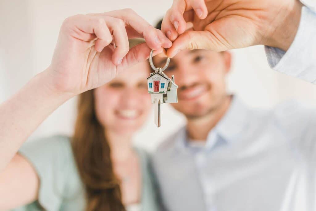 Happy couple holding and showing a house key